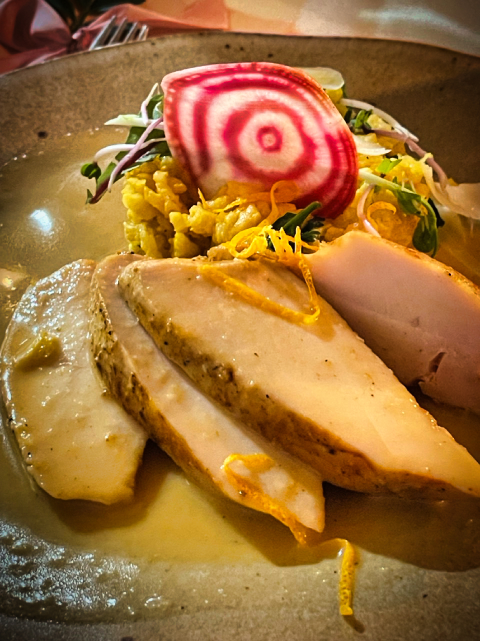 Umelecky podané hlavné jedlo s mäsom, farebnou reďkovkou a žltou zeleninou