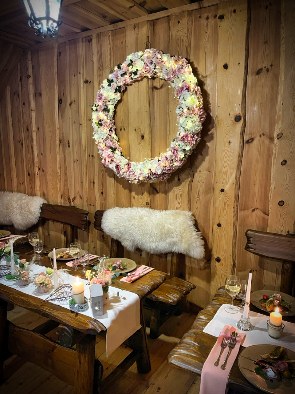 Elegantná jedáleň s veľkým kvetinovým vencom a romantickým prestieraním